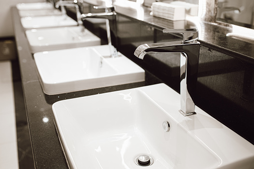 Empty washing hand sinks in public bathroom interior. Healthcare and Hygiene. Public toilets concept.