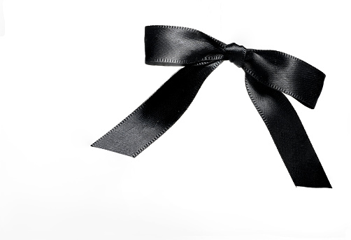 black noble bow loop mesh of black shiny wide ribbon on white background as a concept for mourning loss funeral condolence death commiseration and passing away
