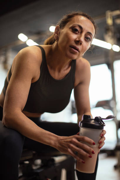 Proud after a workout Fit middle-aged woman resting after her workout at the gym bodybuilding supplement stock pictures, royalty-free photos & images