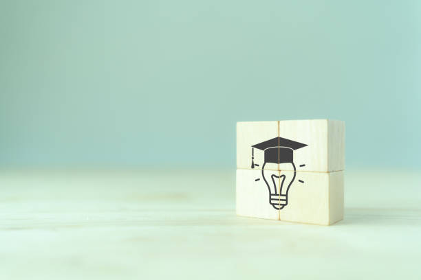 istock Graduation from university, education, diploma concept. Commencement, Graduation day. Personal competency development. Wooden cubes with graduation cap on beautiful grey background and copy space. 1484258790