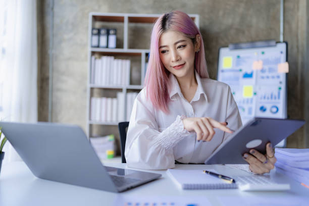 istock Young Asian accountant working in a financial office Manage sales reports using calculator with laptop and financial documents. 1484259382