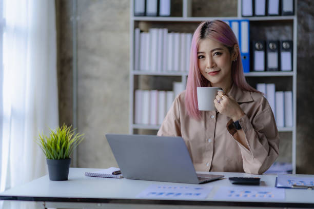 istock Young Asian accountant working in a financial office Manage sales reports using calculator with laptop and financial documents. 1484259385