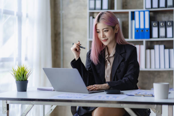 istock Young Asian accountant working in a financial office Manage sales reports using calculator with laptop and financial documents. 1484259620