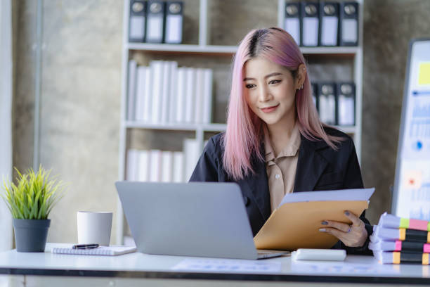 istock Young Asian accountant working in a financial office Manage sales reports using calculator with laptop and financial documents. 1484259644
