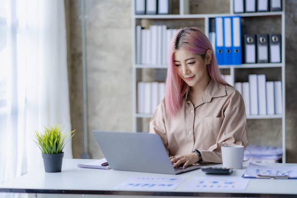 istock Young Asian accountant working in a financial office Manage sales reports using calculator with laptop and financial documents. 1484260283