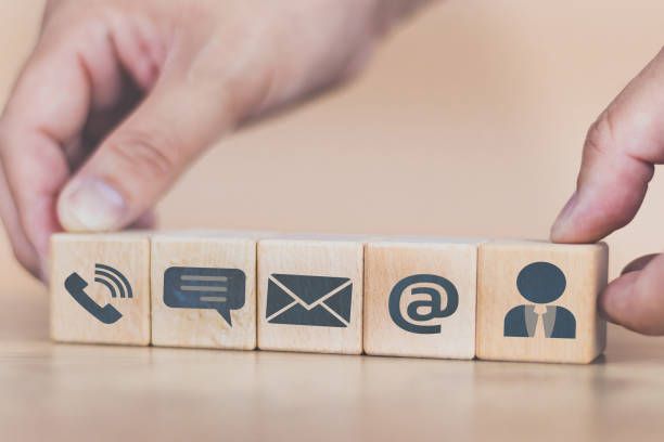 istock Customer support hotline Contact us wood cube concept Man's hand arranges wood cube tiles to show icon. Contact for inquiries, complaints or assistance via telephone, chat, e-mail, website or person 1484261617