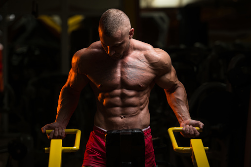 Man Doing Heavy Weight Exercise For Trapezius On Machine