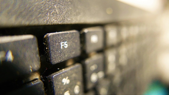 F5 Key on a QWERTY keyboard. Computer parts: dirty keyboard, computer keyboard close-up angle. Keyboard numbers. Keyboard signs. Keyboard buttons. Computer key. Keyboard keys, close-up shot. PC on the table. Also, percentage sign, close-up shot. Keyboard on a table.