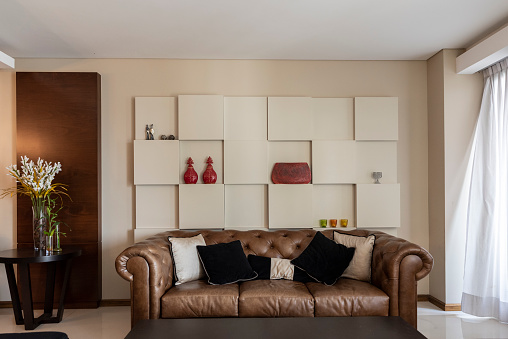Brown leather sofa, table and decor in living room. Home interior
