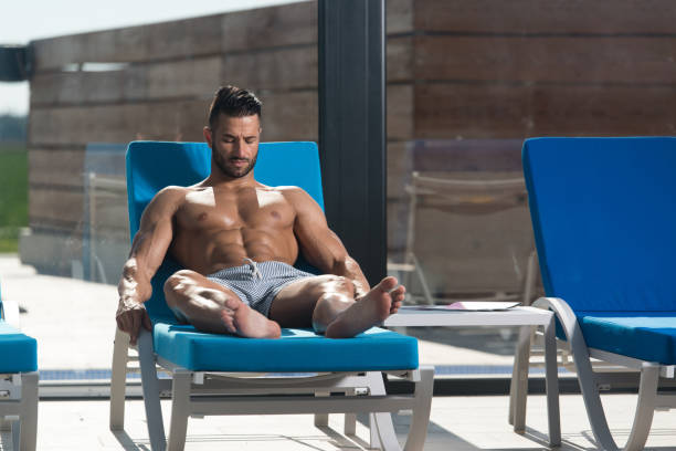 istock Man Resting On Sun Loungers By Swimming Pool 1484263661