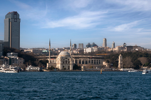 Istanbul, Turkey, 02.25.2023: View of the European part of Istanbul in the Besiktas area and the Sultan Bezmialem Valide Mosque (Dolmabahce Mosque) from the Bosphorus