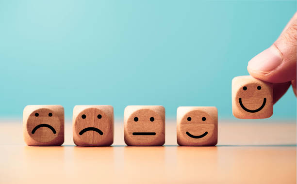 istock Customer satisfaction survey concept, Businessman putting smile face icon which print screen on wooden block cube to evaluate product and service. 1484275433