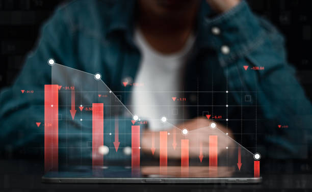 istock Economic collapse concept. Declining graphs and digital indicators show the economic crisis. Depressed businessman with his business investment graph 1484276095