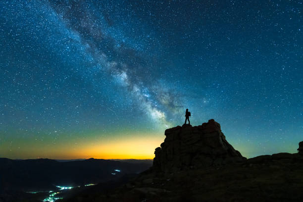 Landscape with Milky Way and silhouette of a hiker man stock photo