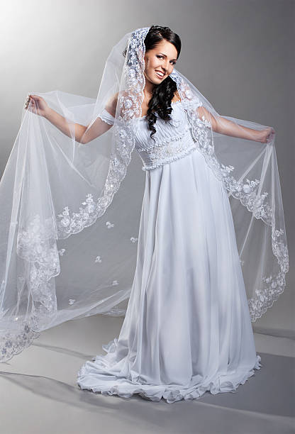 istock beautiful bride is standing in wedding dress 148428161