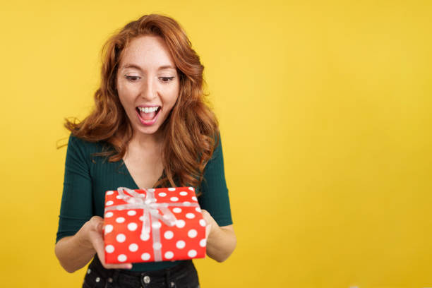 istock Excited redheaded beauty woman holding a gift 1484287284