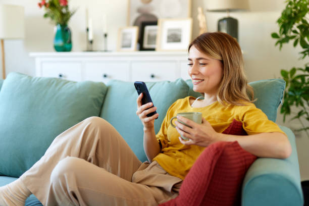 istock Woman using smartphone while drinking coffee at her home in the morning 1484288253