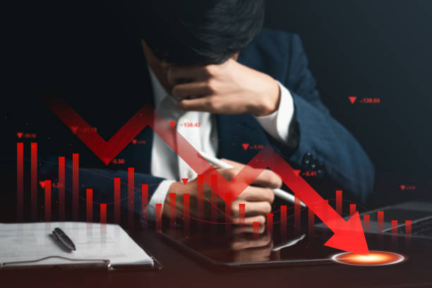 istock Economic collapse concept. Declining graphs and digital indicators show the economic crisis. Depressed businessman with his business investment graph. 1484289396