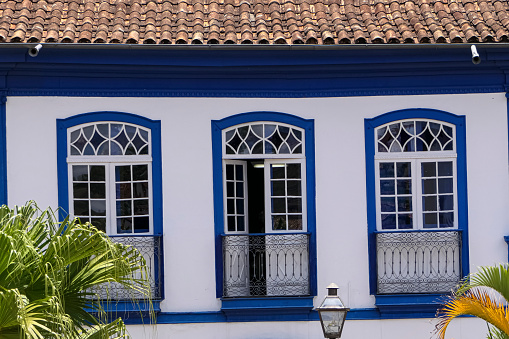 Close-up front view of an historical building with three windows in white and blue, Diamantina, Minas Gerais, Brazil