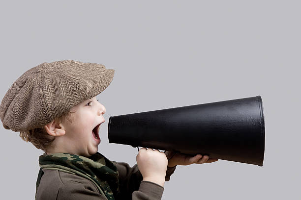 istock Little boy with flat cap shouting on old fashioned megaphone 148429937