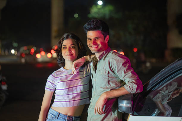 istock Happy couple leaning on car and spending leisure time at night 1484301530