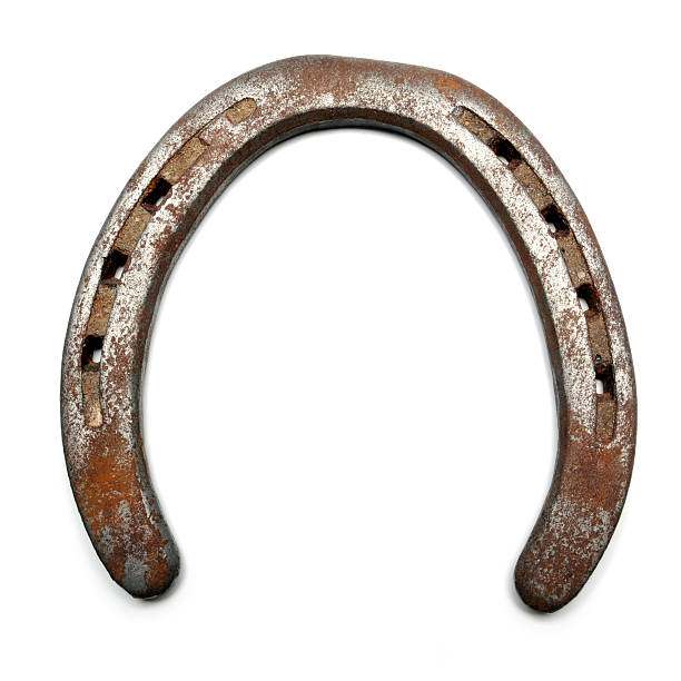Lucky horseshoe isolated on white Closeup of a old, rusty horseshoe. used horseshoes stock pictures, royalty-free photos & images