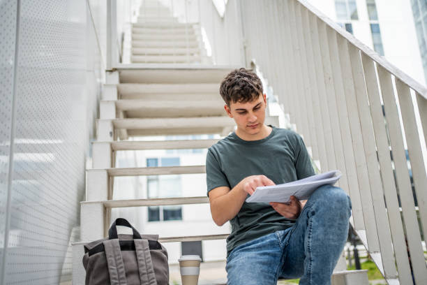 istock A high school student or student sits on the steps of his school building and studies 1484306789