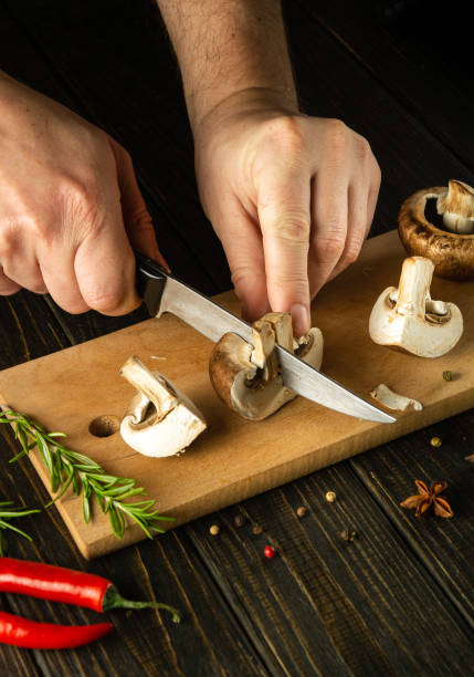 istock The chef hands cut mushrooms with a knife on a kitchen cutting board before preparing a vegetarian dinner with herbs and spices. Copy space. 1484308138