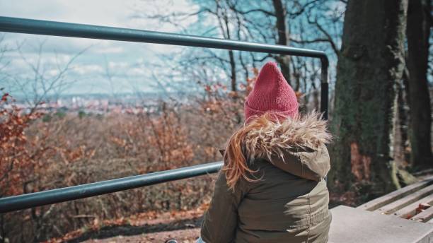 istock Lonely Girl Sitting On Bench at Hill Sightseeing Point Looking at Distant Horizon 1484310529