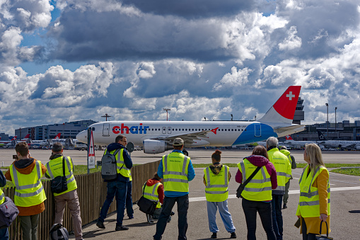 Photographers taking photo of Chair Airbus A320-214 HB-JOB taxiing at Swiss Airport Zürich Kloten on a sunny spring day. Photo taken April 14th, 2023, Kloten, Canton Zurich, Switzerland.