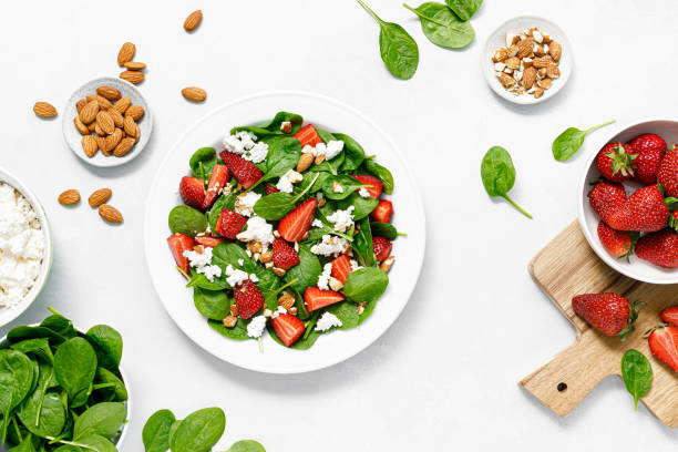 istock Strawberry and spinach fresh salad with cottage cheese and almonds, top view 1484317920