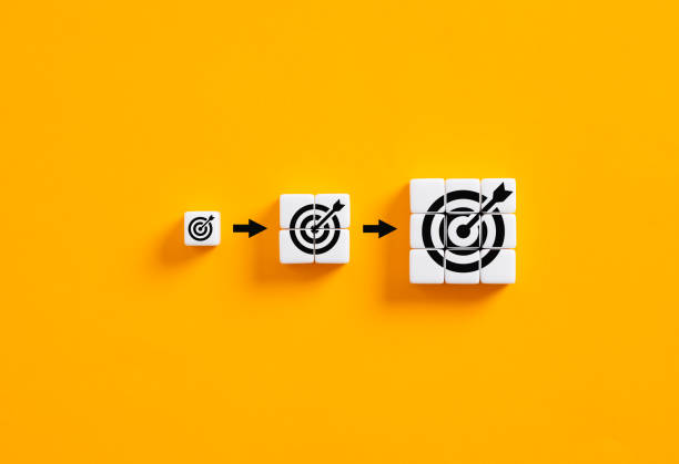 istock Setting business goals. Developing goals and objectives. Growing target symbols on white cubes on yellow background. 1484319424