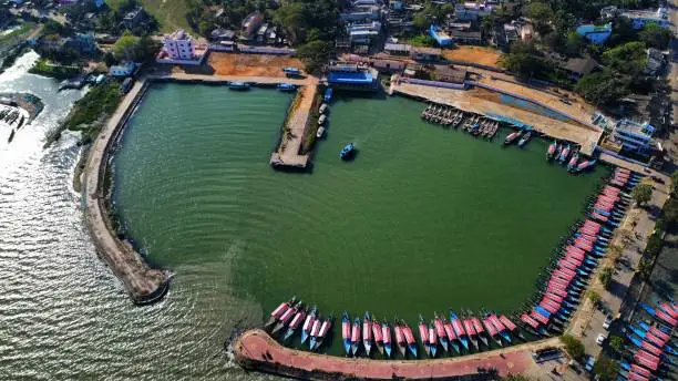 Photo of fishing harbor with lots of wooden boats parked in it arial drone view