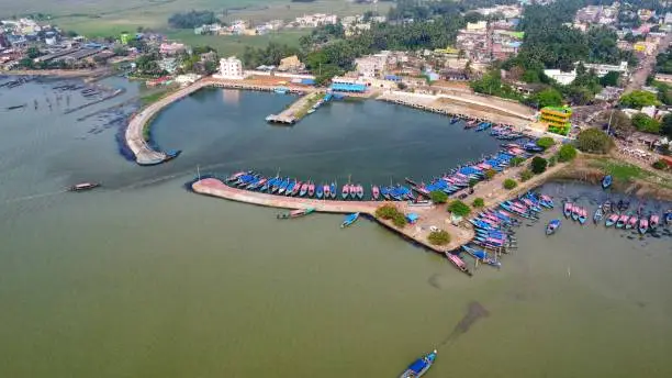 Photo of fishing harbor with lots of wooden boats parked in it arial drone view