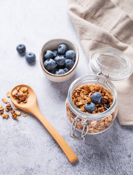 domowa pieczona muesli z orzechami i świeżą jagodą w słoiku na jasnym tle. zdrowe wegetariańskie musli na śniadanie. - jar oatmeal granola glass zdjęcia i obrazy z banku zdjęć