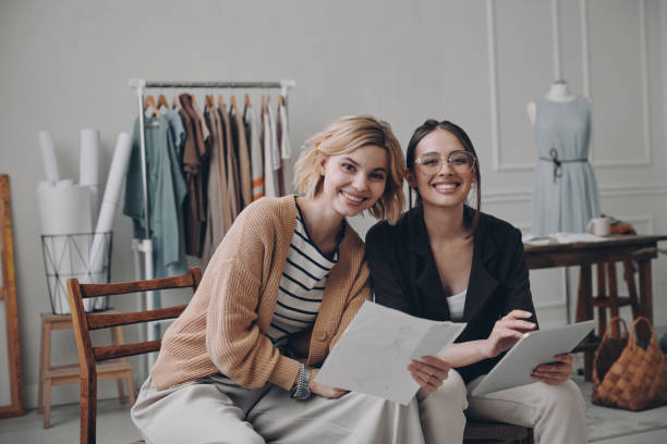 istock Two female fashion designers looking at camera and smiling while working in workshop together 1484322932
