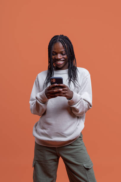 istock Cheerful black woman messaging on smartphone in studio 1484327355