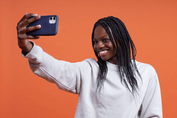 istock Happy black woman taking selfie on smartphone in studio 1484327362