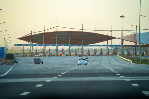 huge toll booth set up on delhi, jaipur, surat, baroda, mumbai highway with cars, trucks and other vehicles coming out after paying through FASTag RFID payment stock photo