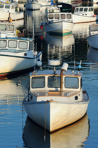 Luxury yachts at sunset. Marina of modern motor and sailing boats in sunshine. Reflection blue sky in water. Sea port dock. Travel and fashionable vacation.