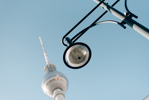 Looking up into a street light with a radio tower in the background