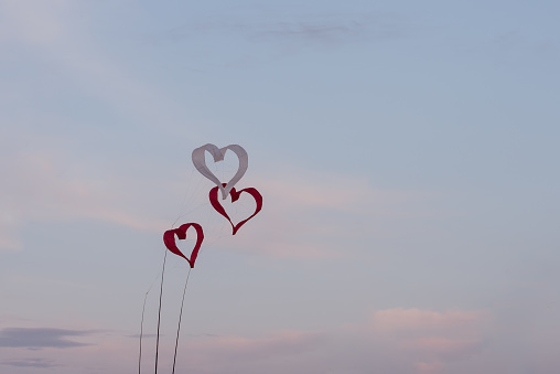 heart shaped wind chimes against a blue sky