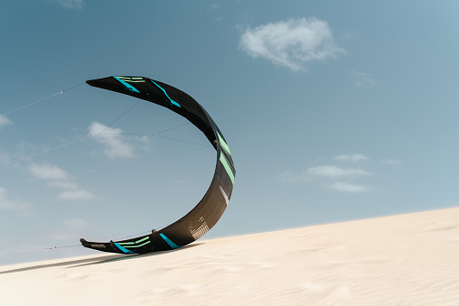 Closeup of a kite sailing on a dune in the desert wind