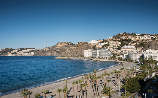 Scenic View of Almunecar Beach and Coastal Townscape with Modern Touristic Buildings and Clear Blue Sea in Granada, Spain