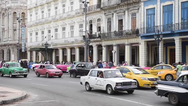 Havana Downtown and Old Town. City Centre and Unique Old Taxi Cars and People In Background. Cuba. Sightseeing.