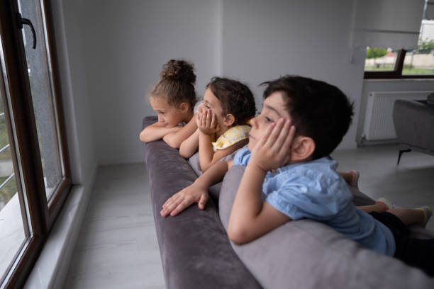 istock Little children watching the rain through the window 1484338620