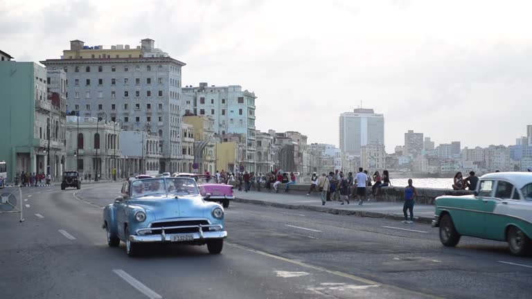 Havana Downtown and Malecon Avenue. Unique Old Taxi Cars and People In Background. Cuba