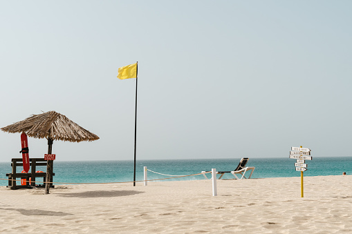 lifeguard hut on the beach with yellow flag