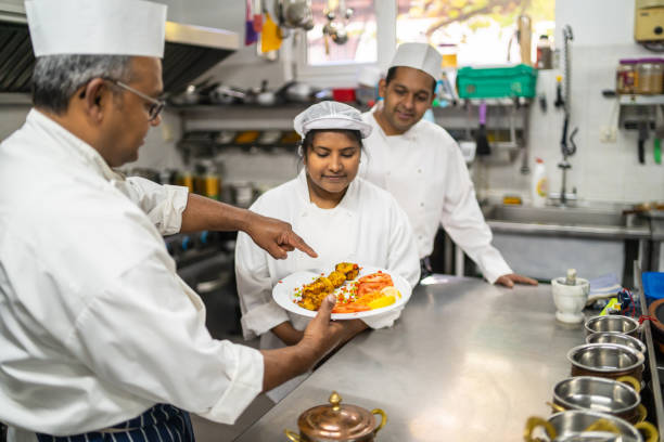 istock A professional chef teaching his co-workers how to plate a meal 1484339340