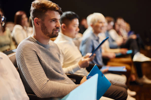 istock Young man attending a seminar in convention center. 1484339469